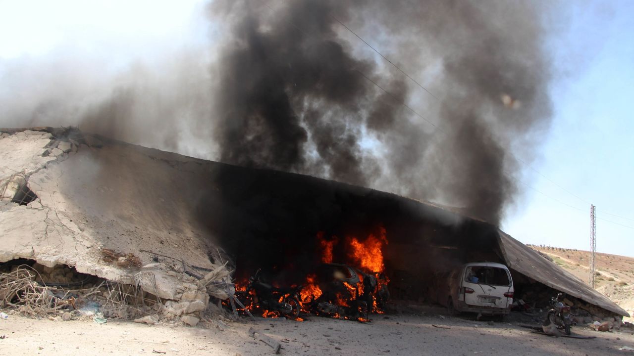 Burning vehicles are seen under the debris of Al-Rahma Hospital.