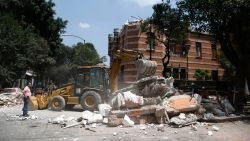 A bulldozer removes debris from a partially collapsed building after an earthquake in Mexico City on September 19.