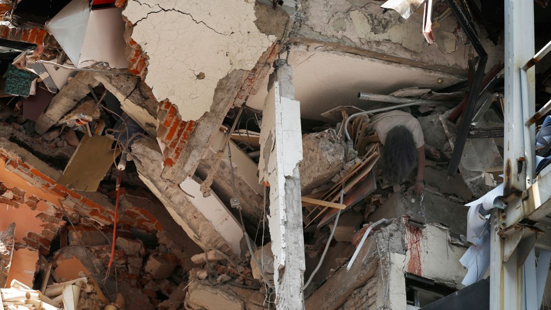 A woman's crushed body hangs from a collapsed building in Mexico City on September 19.