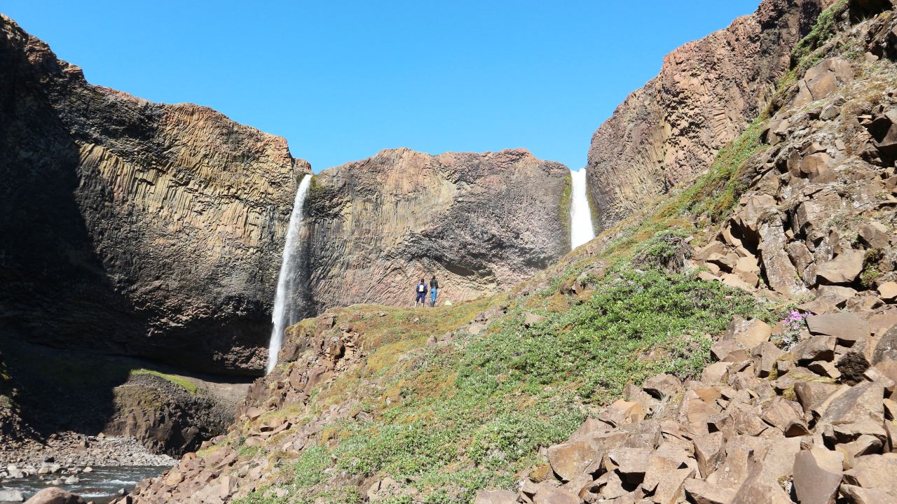 Twin waterfalls crash down from the rock above.