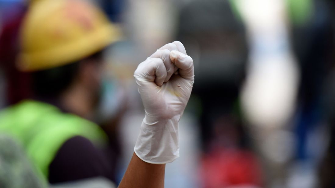 A volunteer in Mexico City asks for silence as a flattened building is searched for survivors on September 20.