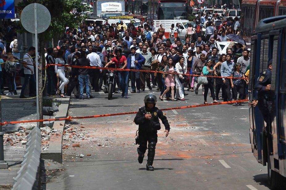 A police officer runs toward the site where a building collapsed in Mexico City on September 19.