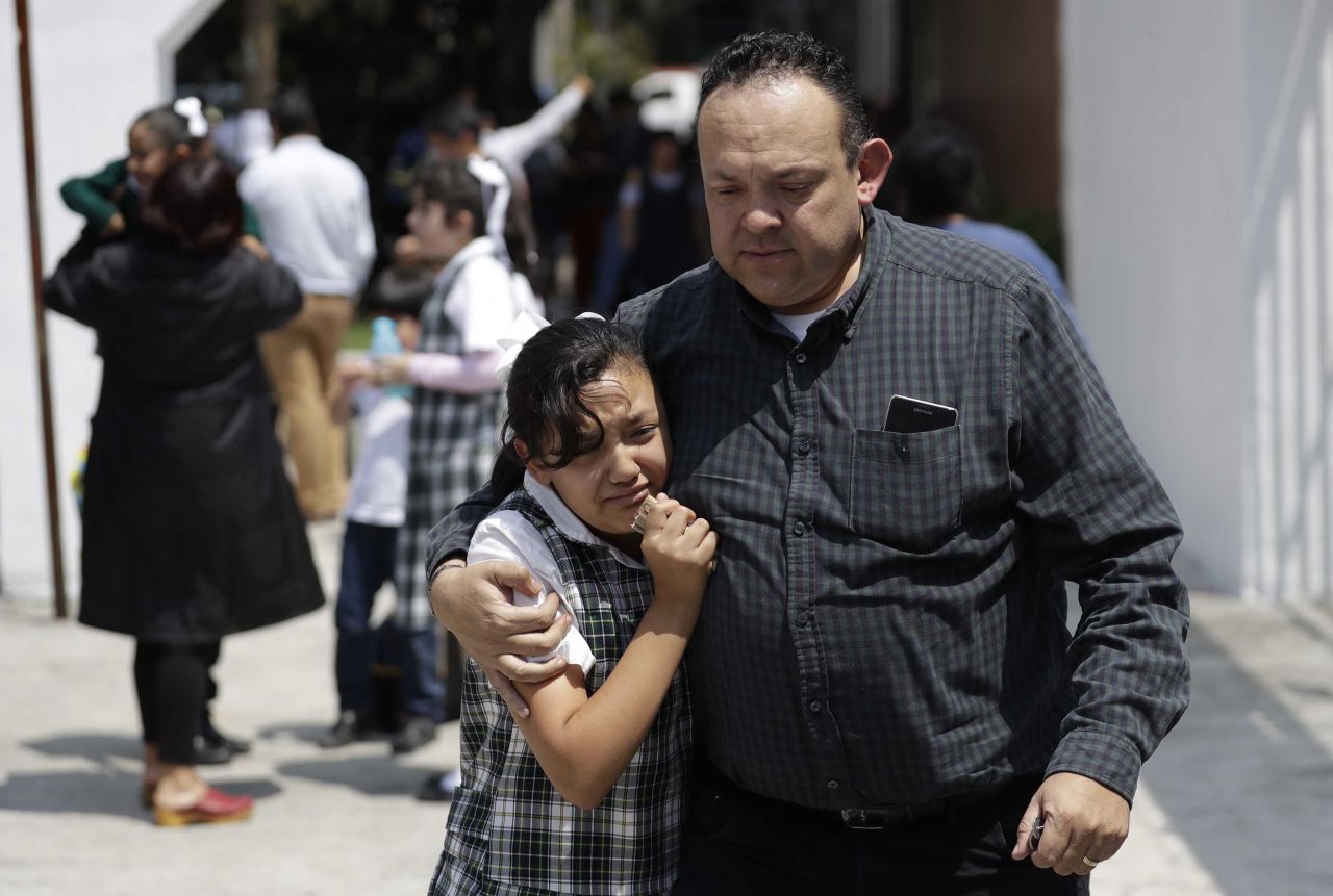 A man comforts a student outside a school in Mexico City on September 19.