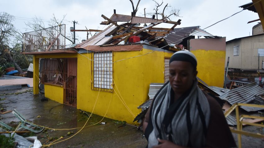 Residents of San Juan, Puerto Rico, deal with damages to their homes on September 20, 2017, as Hurricane Maria batters the island. 
Maria slammed into Puerto Rico on Wednesday, cutting power on most of the US territory as terrified residents hunkered down in the face of the island's worst storm in living memory. After leaving a deadly trail of destruction on a string of smaller Caribbean islands, Maria made landfall on Puerto Rico's southeast coast around daybreak, packing winds of around 150mph (240kph).
 / AFP PHOTO / HECTOR RETAMAL        (Photo credit should read HECTOR RETAMAL/AFP/Getty Images)