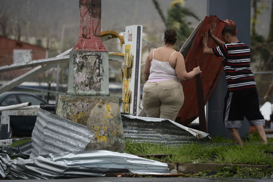 Residents move aluminum panels from an intersection in Humacao on September 20. 
