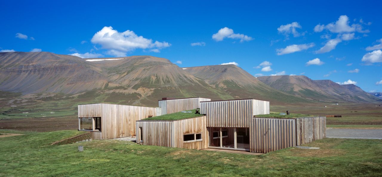 The Hof by Studio Granda sits some 100 kilometers from the Arctic Circle in the Skagafjörður fjord in Iceland. The structures, with cedar and concrete walls, sit atop tufted sites, and its roofs feature grass from the fields. Meanwhile, the walls also provide heavy insulation.