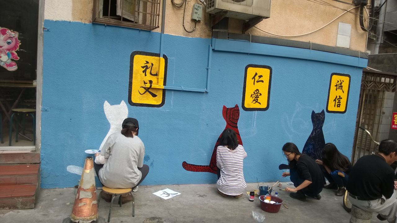 <strong>A community of cat lovers: </strong>Volunteers from local colleges paint murals on Ding'aozai Cat Street. 