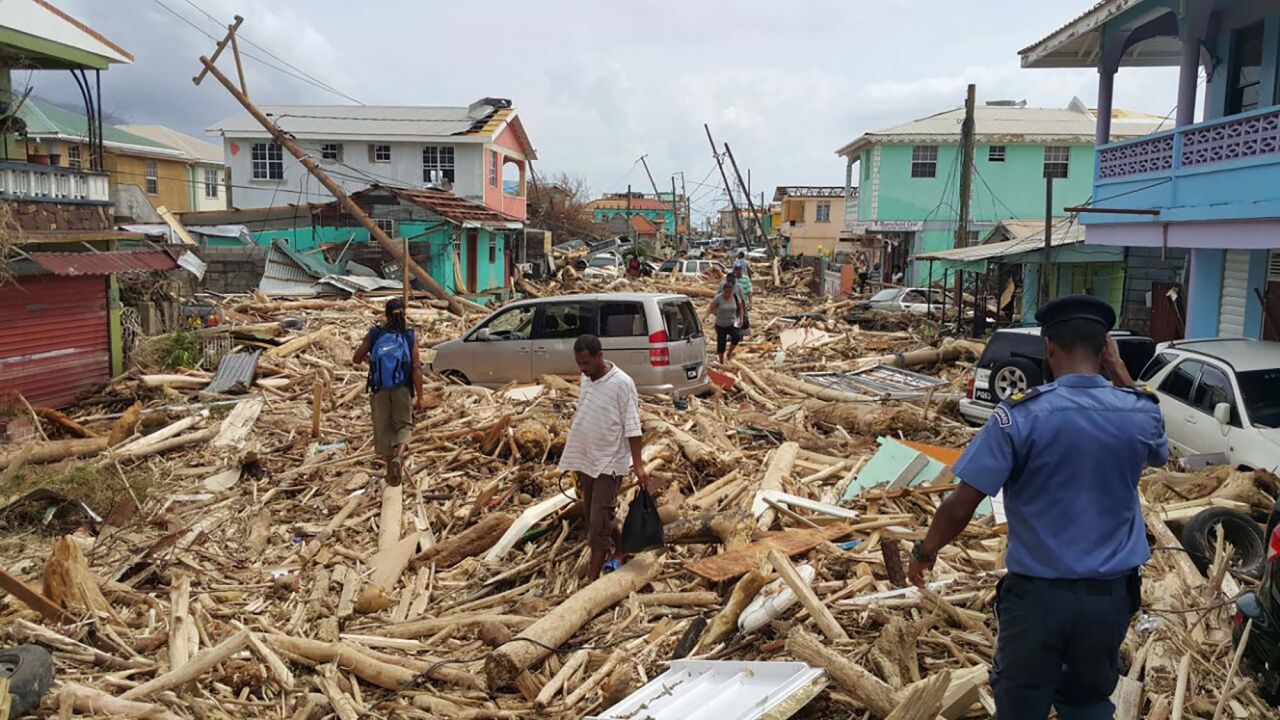 People walk through the destruction in Roseau on September 20.