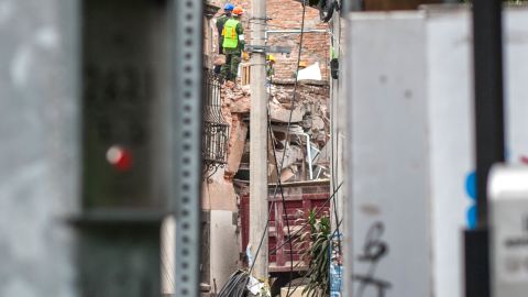 Volunteer rescue workers work to pull out two women from the rubble of what used to be an office building.