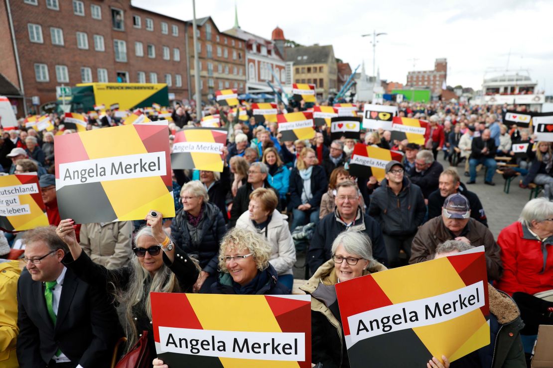 Merkel supporters wave placards at a campaign rally in Kappeln, Germany on September 20.