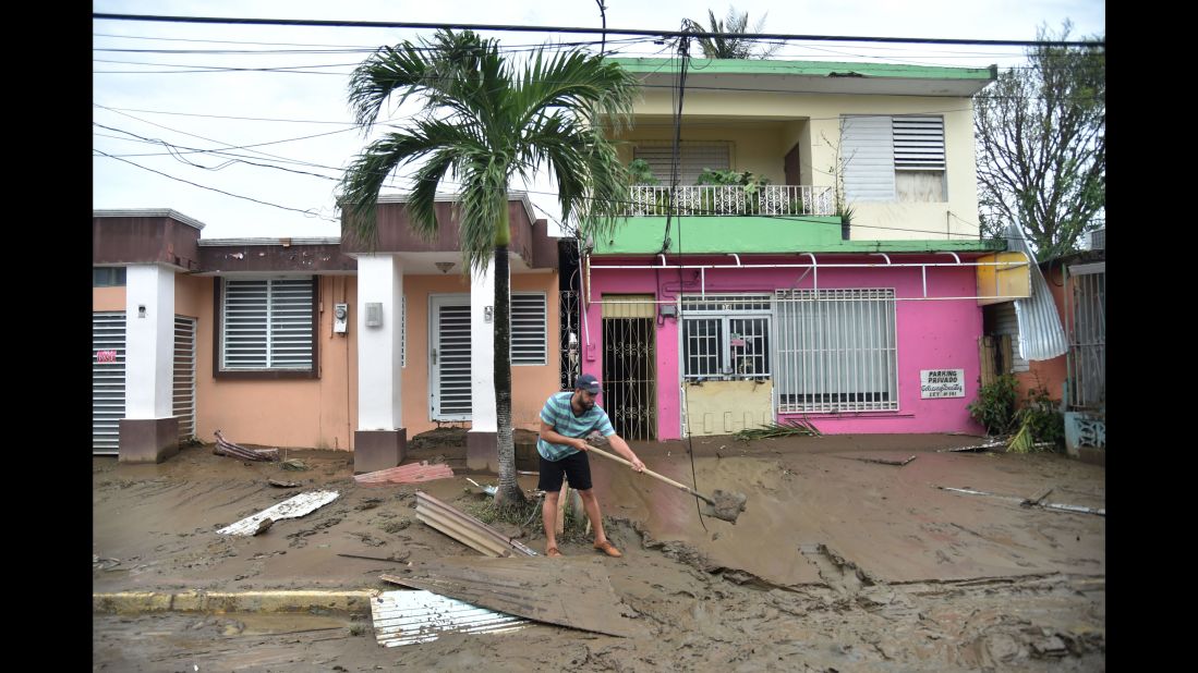 A man cleans a muddy street in Toa Baja, Puerto Rico, on September 22.