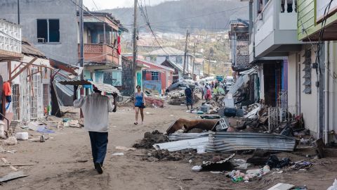 Residents of Roseau, capital of Dominica, walk down a street covered in debris on September 22, four days after Hurricane Maria battered the Caribbean.