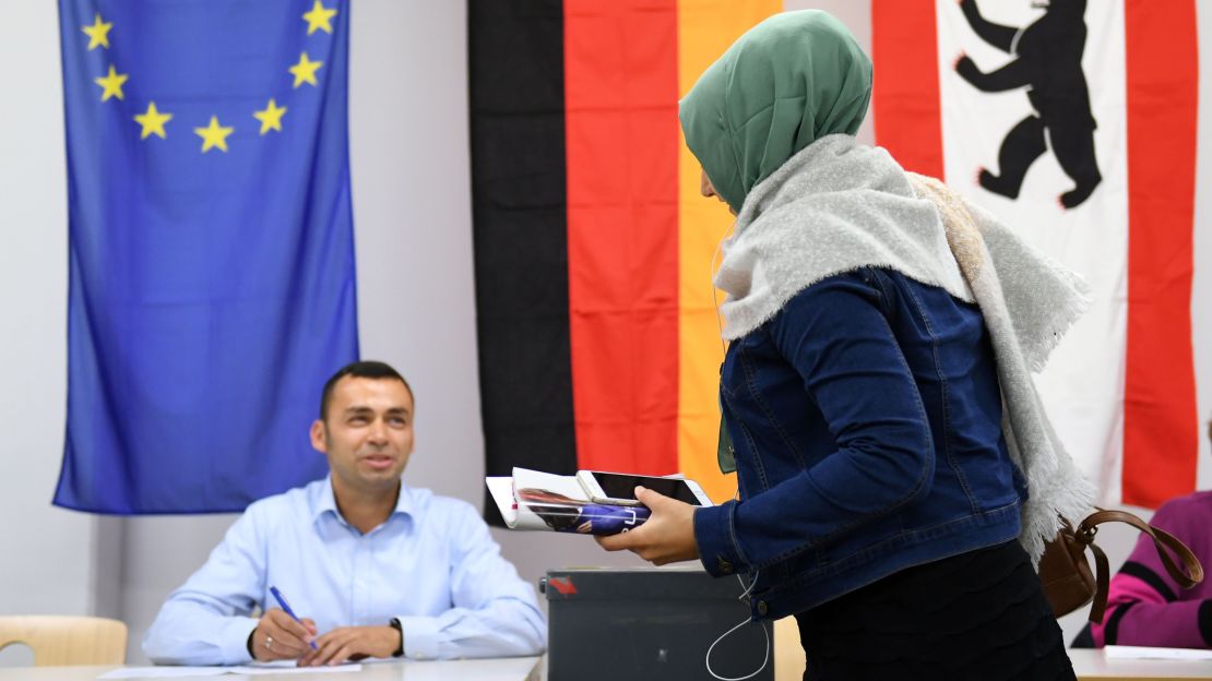A woman wearing a veil casts her ballot at a polling station in Berlin during general elections on September 24.
