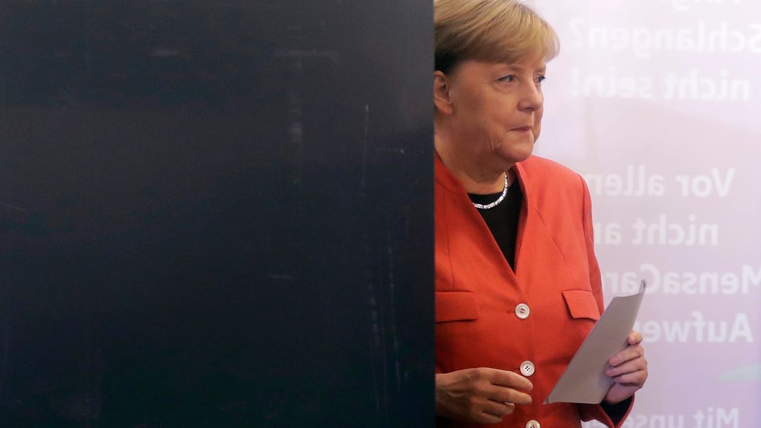German Chancellor Angela Merkel leaves an election booth as she casts her vote in Berlin on Sunday.