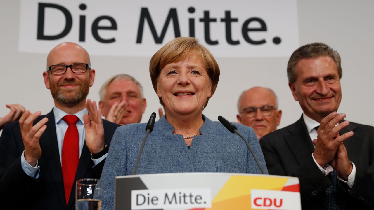 German Chancellor and CDU party leader Angela Merkel (C) addresses supporters after exit poll results were broadcasted on public television at an election night event at the party's headquarters in Berlin during the general election on September 24, 2017.