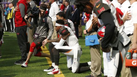 Wide receivers DeSean Jackson, forefront, and Mike Evans take a knee before Sunday's game.