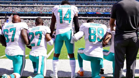 EAST RUTHERFORD, NJ - SEPTEMBER 24: Laremy Tunsil #67, Maurice Smith #27 and Julius Thomas #89 kneel with Jarvis Landry #14 of the Miami Dolphins during the National Anthem prior to an NFL game against the New York Jets at MetLife Stadium on September 24, 2017 in East Rutherford, New Jersey.  (Photo by Steven Ryan/Getty Images)