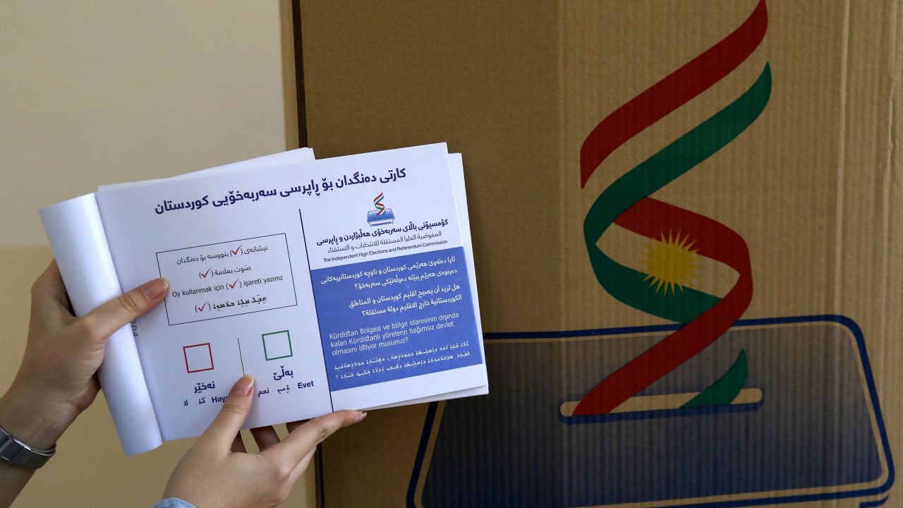 An employee from the Independent High Electoral Referendum Commission holds a voting ballot book at a polling station.