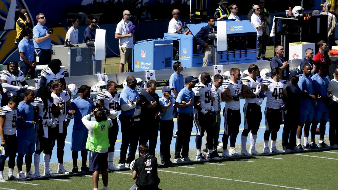 Members off the Los Angeles Chargers lock arms in protest before a football game against the Kansas City Chiefs.