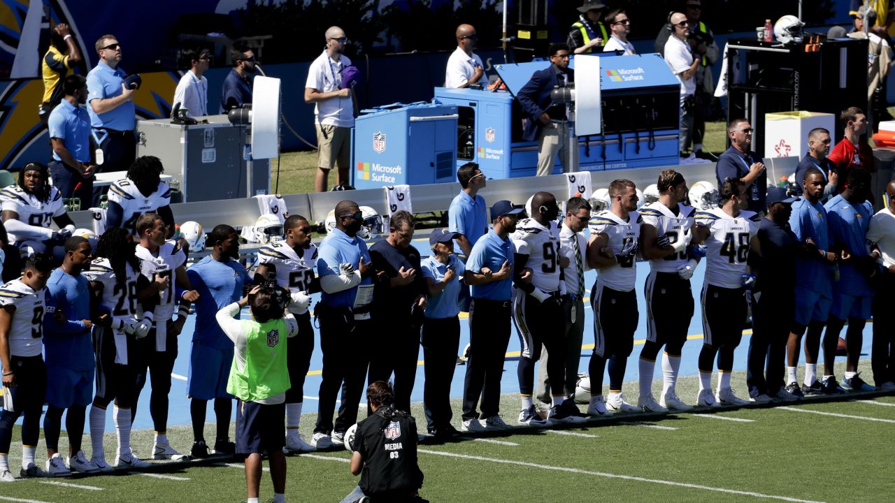 Members off the Los Angeles Chargers lock arms in protest before a football game against the Kansas City Chiefs.