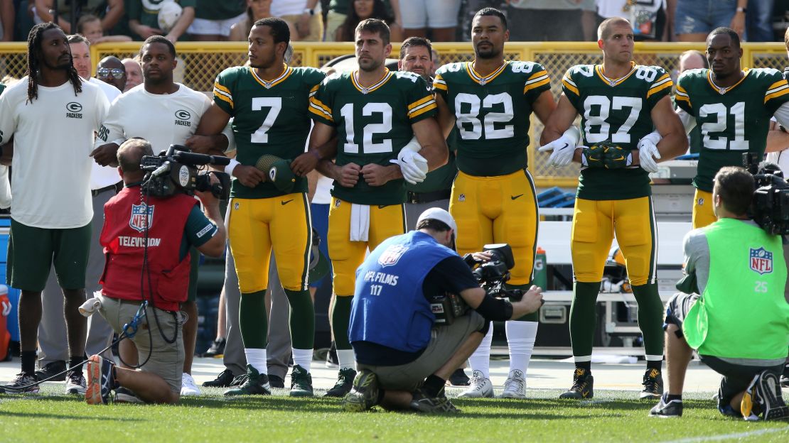 Members of the Green Bay Packers stand with arms locked as a sign of unity during the national anthem prior to their game against the Cincinnati Bengals at Lambeau Field on Sunday.