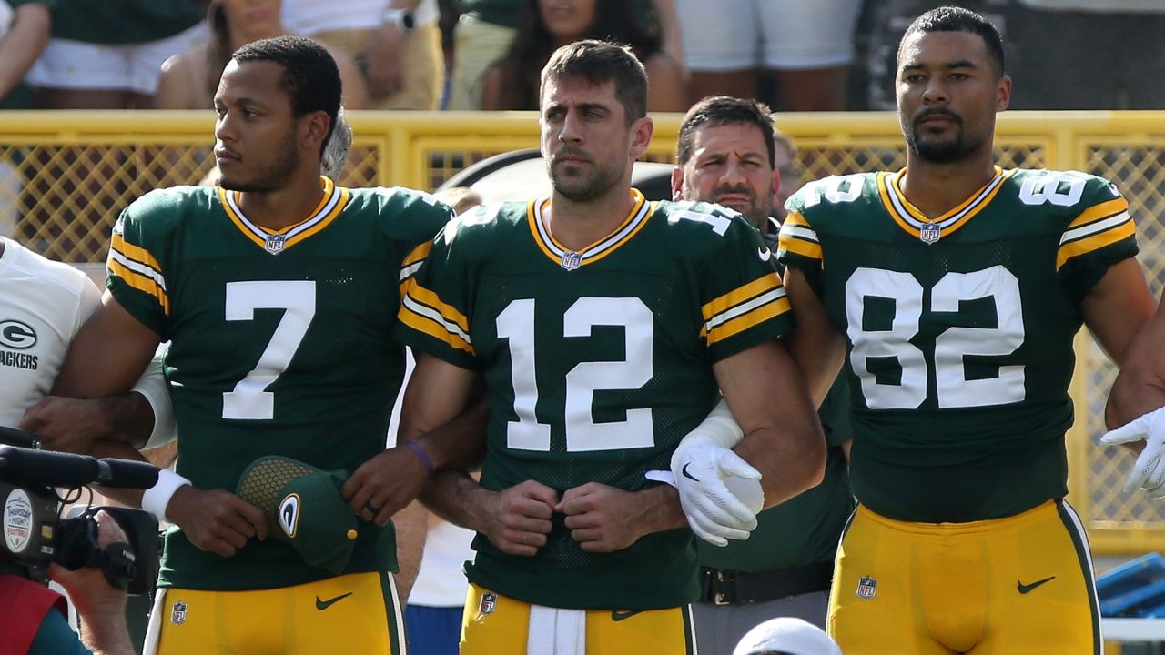 Green Bay Packers players, including quarterback Aaron Rodgers, stand with arms locked during the national anthem before their game against the Cincinnati Bengals.