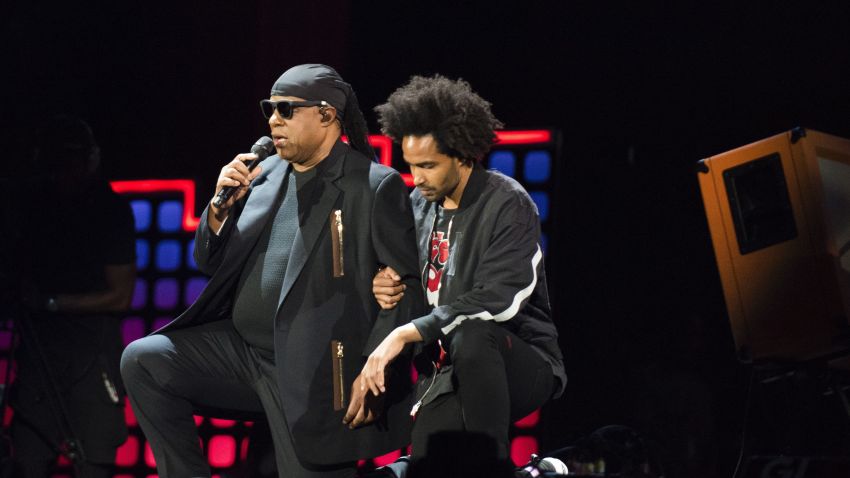 Stevie Wonder, left, takes a knee "for the country" with his son, Kwame Morris, before performing at the 2017 Global Citizen Festival in Central Park, Saturday, Sept. 23, 2017, in New York. The festival aims to end extreme poverty through the collective actions of Global Citizens by 2030.  (AP Photo/Michael Noble Jr.)