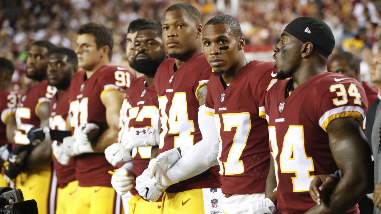 Member of the Washington Redskins stand arm in arm during the playing of the National Anthem on September 24. 