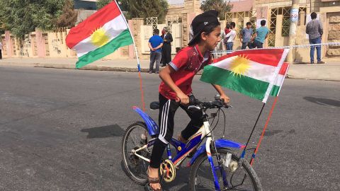 A boy rides a bike outside of polling station.