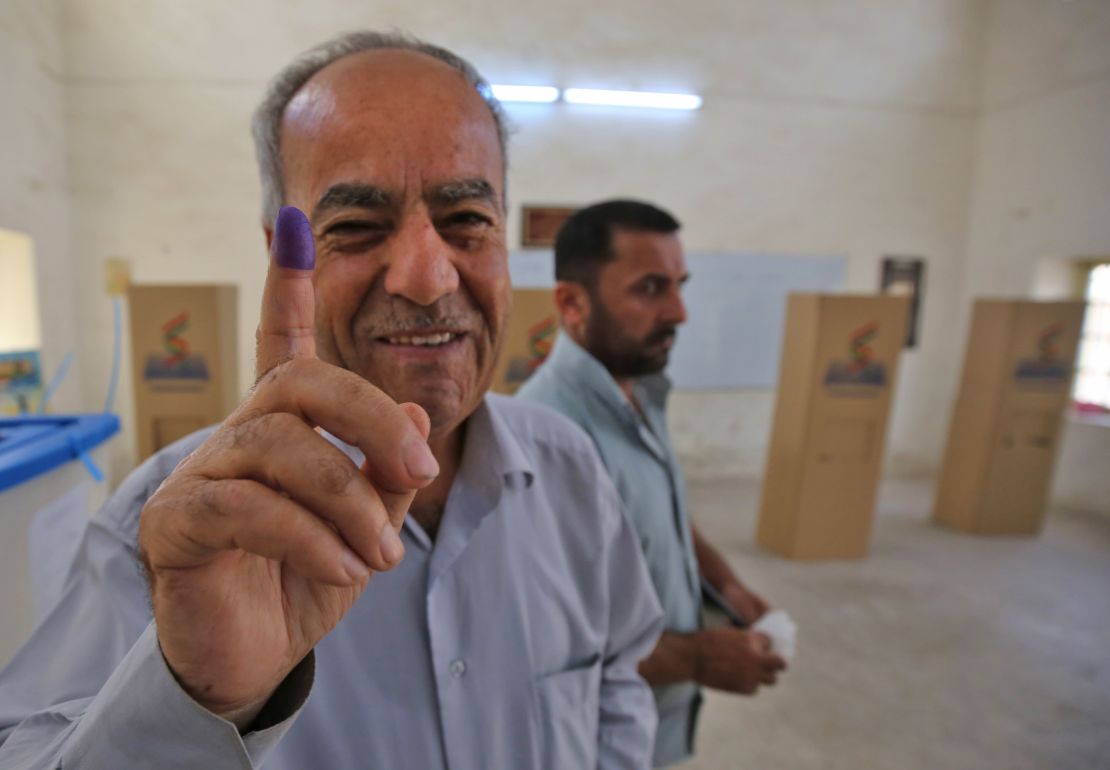 An Iraqi Kurdish man shows his ink-stained finger after voting in Kirkuk on Monday. 