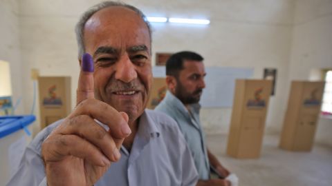 An Iraqi Kurdish man shows his ink-stained finger after voting in Kirkuk on Monday.