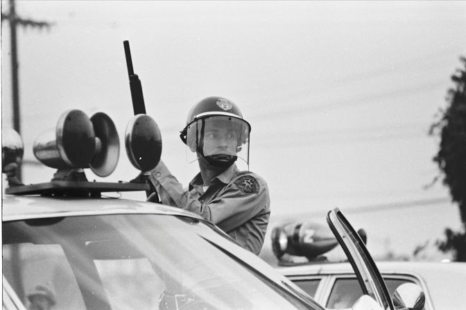 A police deputy with shotgun raised outside of a National Chicano Moratorium march in August 1970 that attracted between 20,000 and 30,000 demonstrators.