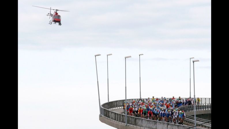 A helicopter flies over cyclists crossing a bridge in Bergen, Norway, during the Road World Championships on Sunday, September 24.