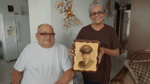 Miguel Olivera and his wife Diana Aponte show a picture from his time in service.