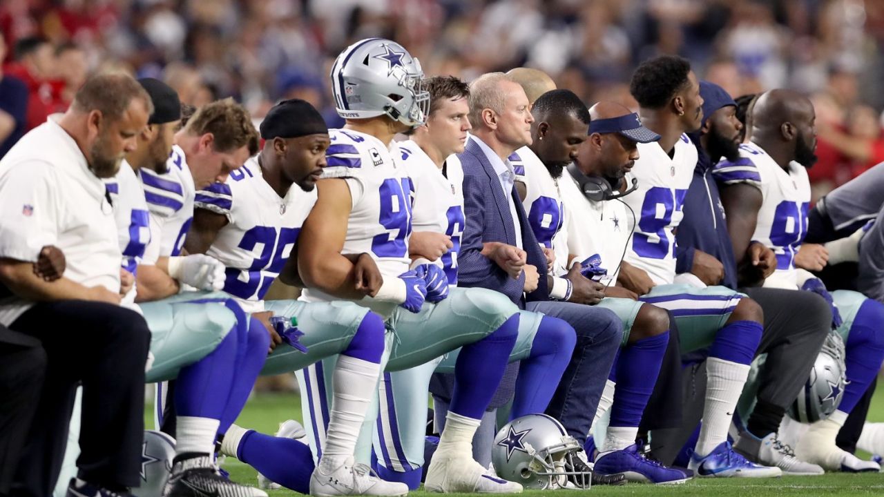 Members of the Dallas Cowboys link arms and kneel during the National Anthem before the start of the NFL game against the Arizona Cardinals on September 25, 2017 in Glendale, Arizona.