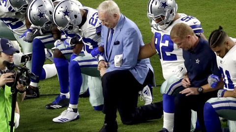 Owner Jerry Jones, center, takes a knee Monday with his team prior to the National Anthem.