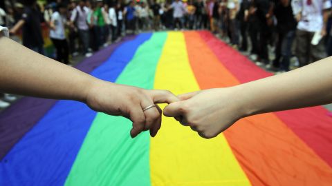 Gay and lesbian activists form a human chain around a rainbow flag during celebrations marking the fourth annual International Day Against Homophobia (IDAHO) in Hong Kong on May 18, 2008. 