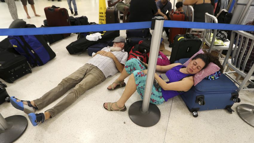 In this Monday, Sept. 25, 2017 photo, stranded passengers rest in the main international airport in the aftermath of Hurricane Maria, in San Juan, Puerto Rico. (AP Photo/Gerald Herbert)