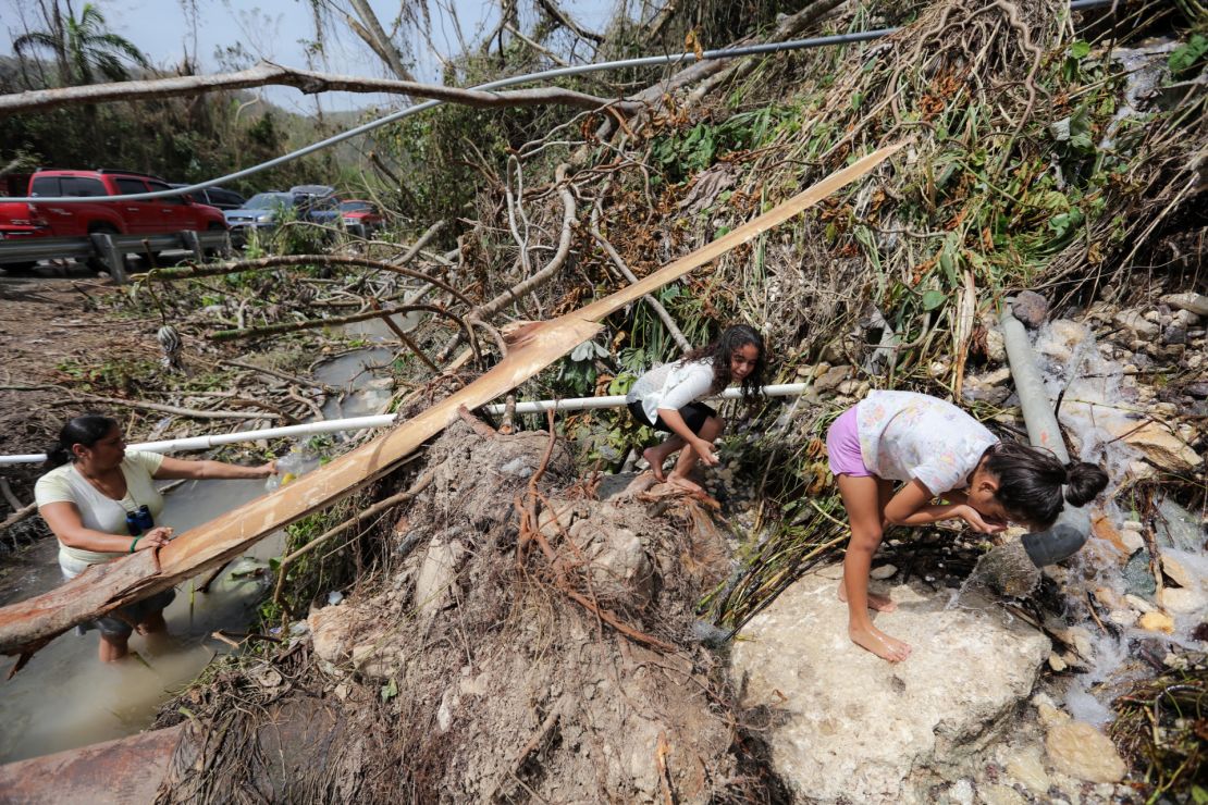 Utuado residents are using a pipe in the highway to get water for cleaning and drinking.