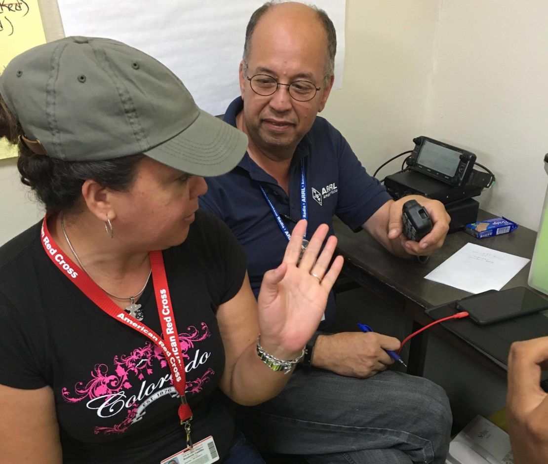 Oscar Resto works with another volunteer to pass along information at the Red Cross headquarters in San Juan, Puerto Rico.
