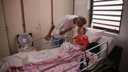 SAN JUAN, PUERTO RICO - SEPTEMBER 26: Rafael Robles-Ortiz kisses his mother Josefina Ortiz who is staying at the Hermanitas de los Ancianos Desamparados facility which cares for the elderly as they deal with the aftermath of Hurricane Maria on September 26, 2017 in San Juan, Puerto Rico. Mr. Robles-Ortiz is concerned for his mother and hopes aid -- including fuel for the facilities generators, as well as food and medicine for his mother -- gets through after Hurricane Maria, a category 4 hurricane, devastated the island.  (Photo by Joe Raedle/Getty Images)