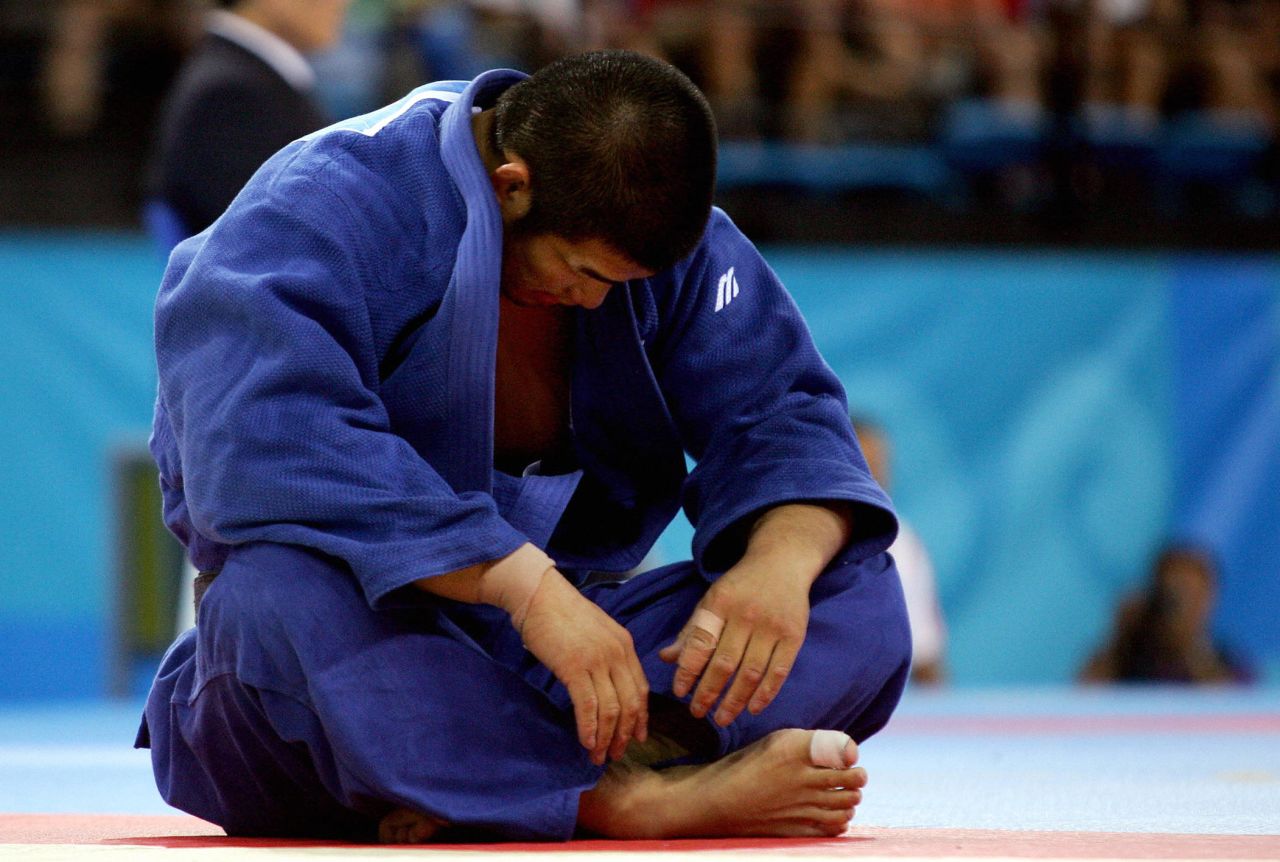 Inoue sits dejected after a loss to Dutch opponent Elco van Der Geest in men's -100 kg competition at the Athens 2004 Olympic Games.