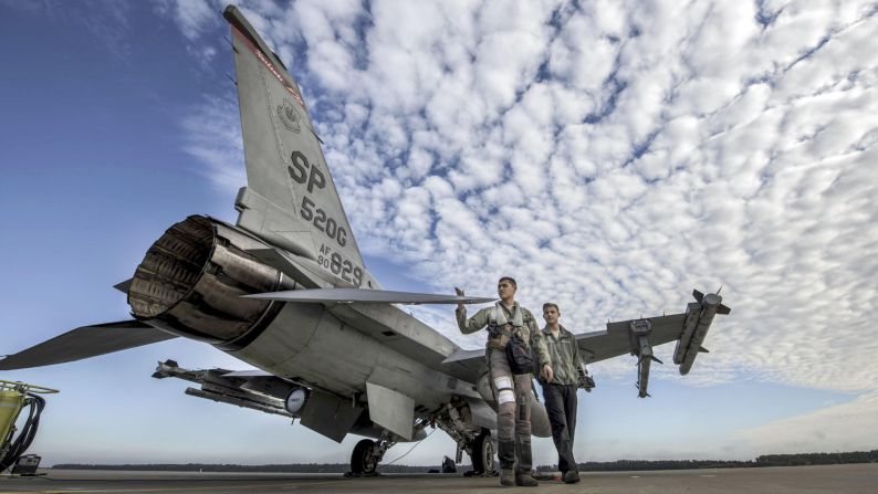 An Air Force pilot and crew chief conduct a pre-flight inspection at a base in Krzesiny, Poland, on Monday, September 11.