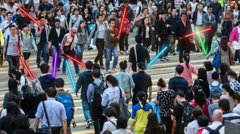 <strong>'Every street is a battlefront': </strong>Pedestrians crossing the busiest road in Causeway Bay, Hong Kong are armed with lightsabers by Fung.