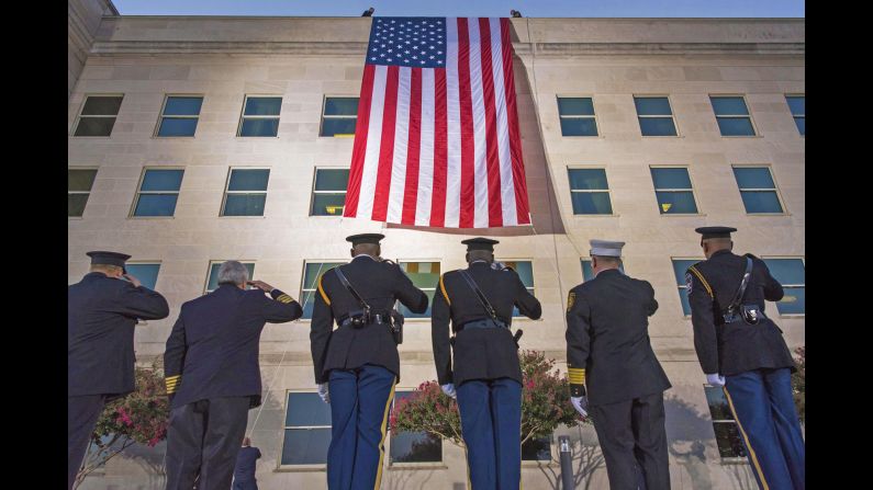 First responders salute a large American flag as it's unfurled over the west side of the Pentagon on Monday, September 11. <a  target="_blank">See US military photos from August</a>