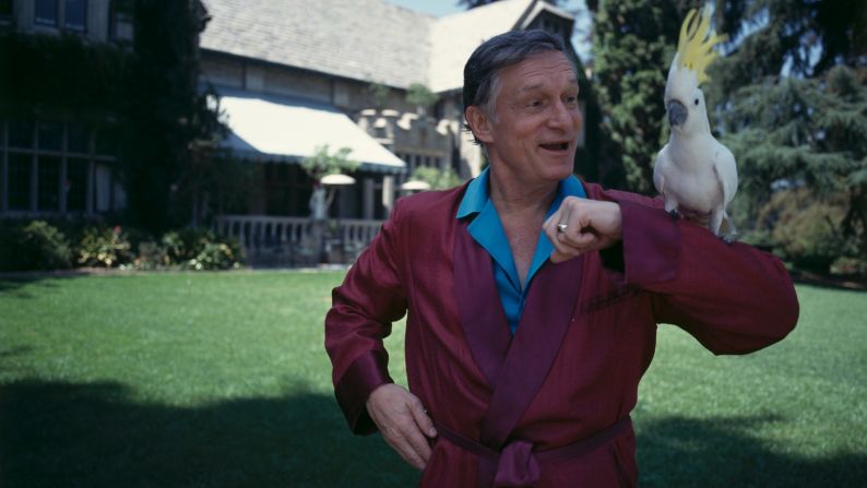 Hefner poses with a cockatoo in one of his iconic silk robes at the Playboy Mansion in November 1993.