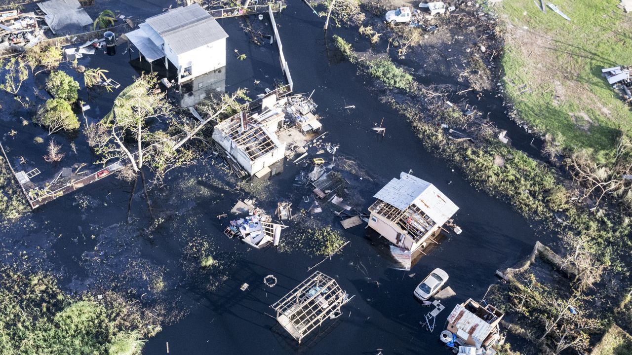 Destroyed homes and vehicles sit in floodwaters after Hurricane Maria