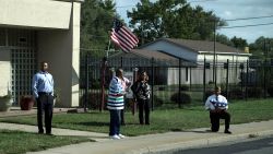 A man takes a knee while holding an American flag as a motorcade with US President Donald Trump drives to Indianapolis International Airport September 27, 2017 in Indianapolis, Indiana. / AFP PHOTO / Brendan Smialowski        (Photo credit should read BRENDAN SMIALOWSKI/AFP/Getty Images)