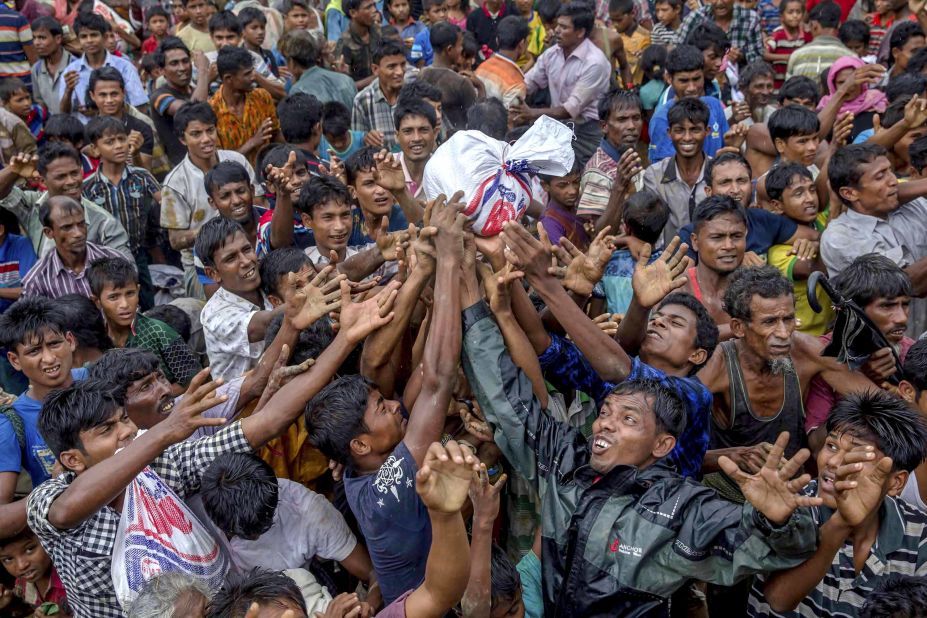 People scramble to catch food distributed by aid groups on September 18 at the Balukhali refugee camp in Bangladesh.