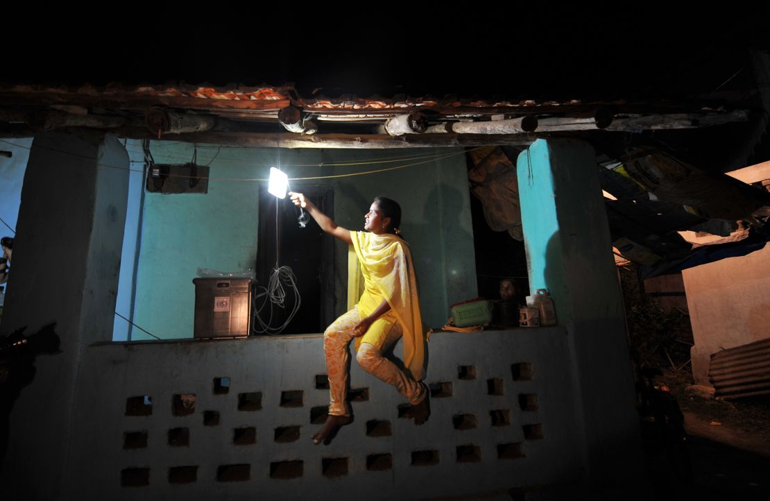 A girl switches on a light powered by solar energy in the village of Morabandar on Elephanta Island, off the coast of Mumbai.